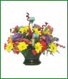 A colorful arrangement in basket of yellow daisies, red carnations, alstroemeria and mini carnations.