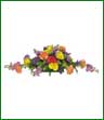 An oblong centerpiece arrangement of yellow roses, purple stock, orange carnations and statice.