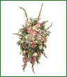 A standing spray of lilies, gladiolus, roses and more. Shown in shades of pink and white.  Appropriate for funeral home.
