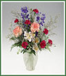 A  vase of alstroemeria, delphinium, spray carnations and limonium.