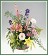 A basket featuring an array of delphinium, asiatic lilies, solidaster, daisy spray mums and monté casino asters.