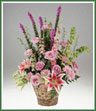 A romantic collection of roses, liatris, moluccella, Stargazer lilies, larkspur, solidaster and daisy spray mums in a handled basket.