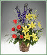 Bright vivid colors of hybrid delphinium, yellow asiatic lilies and orange Star 2000 roses with spiral eucalyptus.
