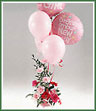 An arrangement of pink carnations, roses, gerbera and babys breath with a bouquet of helium balloons.