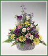 An abundant collection of delphinium, roses, miniature carnations, lisianthus, daisy spray mums and sword fern in a basket.