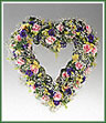 A heart of delicate flowers, miniature carnations, alstroemeria, cornflower and gypsophila. Appropriate for funeral home.