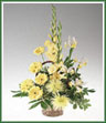 All yellow gladioli, Fuji chrysanthemums, gerbera and iris in a natural basket.
