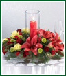 A Christmas centerpiece with a contemporary flair. Red Asiatic lilies and deep red spray roses are accompanied by green roses and 
