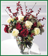 A presentation in red and white to celebrate the romance of the Holidays. Breathtaking white and red roses, white waxflower, holly and red berries are combined in this engaging bouquet. Sure to set a warm, festive mood!