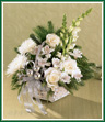 Still and serene as a crisp morning snow, this basket of white blossoms - Fuji mums, roses, snapdragons and alstroemeria - show brightly against rich Christmas greens. Trimmed with silver ribbon and glass ornaments, it's a wonderful holiday gift for family and friends. Style of basket may vary.