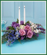 Celebrate the Festival of Lights with this beautiful tribute to the season. Lavender roses, purple lisianthus and blue delphinium share the glow with star-white alstroemeria. Two white taper candles make this a lovely centerpiece for friends and family to enjoy.