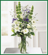 Imagine an enchanting spring garden. This bouquet makes it real - lovely white lilies, lisianthus and freesia combine with stately blue belladonna, Bells of Ireland, and purple iris. Best of all, you can bring this garden indoors. Style of vase may vary.