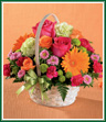 Send a bouquet as lovely as a summer garden. Orange Gerbera daisies and orange roses alongside hot pink roses and mini carnations are a real attention-getter! Perfectly accented with pistachio carnations and button pompons, this sweet basket is as refreshing as a walk in the park! Style of basket may vary.
