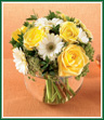 This petite bouquet of bright yellow roses, white Gerbera daisies and summery Queen Anne's lace is gathered with huckleberry into a clear glass bubble bowl, ready to put a smile on your recipient's face. This is the perfect gift for any occasion, or just to show you care.