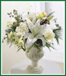 This festive arrangement in winter white is a great holiday gift or decoration. White lilies, white lisianthus, white freesia and white carnations are professionally arranged in a glass vase.