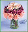 Pretty petals in a tiered design make a unique bouquet. Pink carnations form the first tier; deep lavender alstroemeria fill the center, and three luscious pink roses are the crowning touch. A stylish design for anyone who appreciates something above the ordinary. Style of vase may vary.