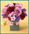 What a beautiful mix! All shades of purple! Lavender roses, purple carnations and variegated mini carnations mingle freely with deep purple cushion poms and statice. All are arranged in a square ceramic vase trimmed with a lavender ribbon. If they love purple - they'll love this bouquet! 