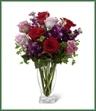 The Garden Walk Bouquet is an exquisite expression of natural beauty and grace. Assorted lavender roses, rich red roses, purple stock and lush greens have a fresh look of floral elegance presented in a modern clear glass vase to create a sweet sentiment ideal to celebrate any of life's special moments. 